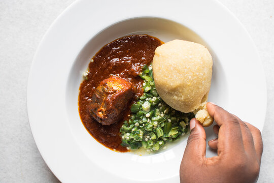 Nigerian okro and stew with eba in a white plate, top view of okro soup and eba