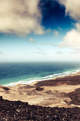 Obraz premium Awesome coastline landscape with ocean blue and mountains with horizon and clouds - beautiful world wild nature place for vacation and adventure summer