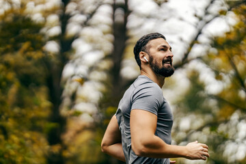 A fit sportsman is running in nature.