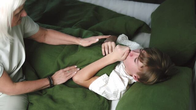 Cough, sick and mother with child in bedroom for medical, help and first aid. Virus, monitor and healthcare with worried woman and check on boy in bed in family home for support, influenza and care