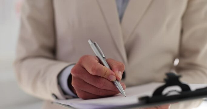 Businesswoman makes quick annotations on clipboard notepad