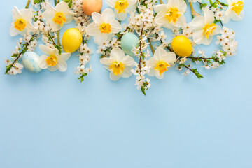 Festive background with spring flowers and Easter eggs, white daffodils and cherry blossom branches...