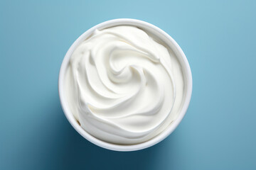 Creamy White Yogurt Swirl: A Deliciously Light and Healthy Homemade Snack, a Tempting Dairy Delight on a Smooth Blue Background.
