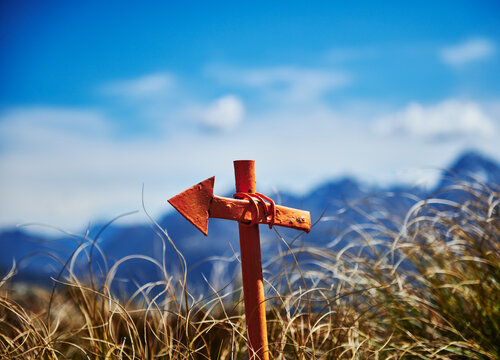 Orange arrow signaling the direction of the trail along Routeburn Track trail , Fjiordland National Park, South Island, New Zealand 