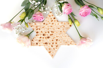 Passover. Traditional Matzo shape of star Magen David  decorate by pink flowers on white background. top view. Holiday of Jewish people, Spring Holiday. Fasting time