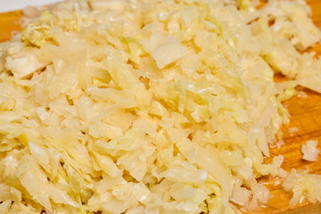 Sauerkraut on a wooden chopper ready to be cooked.