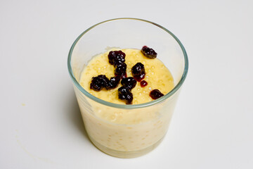 a glass bowl with dessert, tapioca pudding with vanilla and blueberry jam.