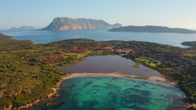 4k drone flight back footage (Ultra High Definition) of Salina Bamba beach with Tavolara mountain on background. Incredible morning view of Sardinia island, Italy, Europe.