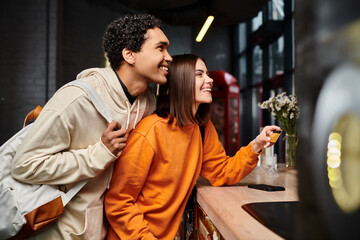 african american man and happy woman holding credit card at reception counter in hostel, travel