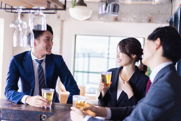バーでお酒を飲む男女の会社員