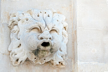close up of a marble fountain element with a head in the middle