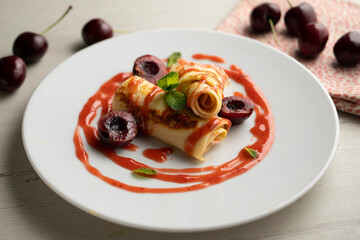 Delicious French crepes with fresh cherries and red fruit syrup.