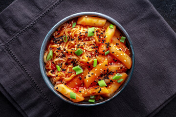 Rabokki, tteokbokki or topokki with ramen, Korean street food, spicy rice cakes in red pepper gochujang sauce, overhead flat lay shot