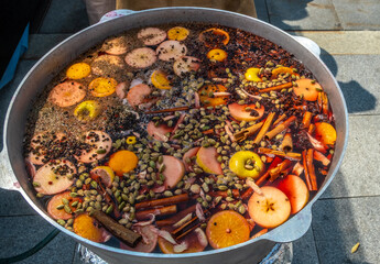 Mulled wine with fruits is prepared in large quantities in a vat.
