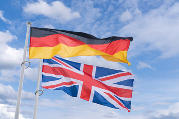 UK and German flags flutter in the wind - obrazy, fototapety, plakaty