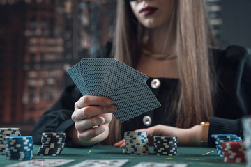 Portrait of young lady playing poker at casino