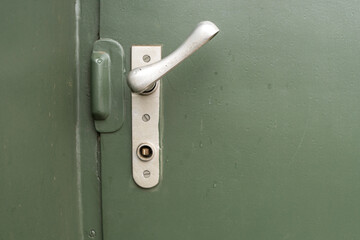 Door handle from a train waggon with green background