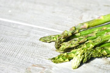 Close up freshly harvested asparagus on the white wooden table.