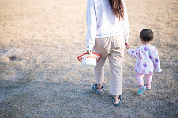 Mother and daughter playing and running around the park on beautiful morning.