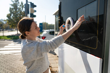 Woman uses a self service machine to receive used plastic bottles and cans on a city street