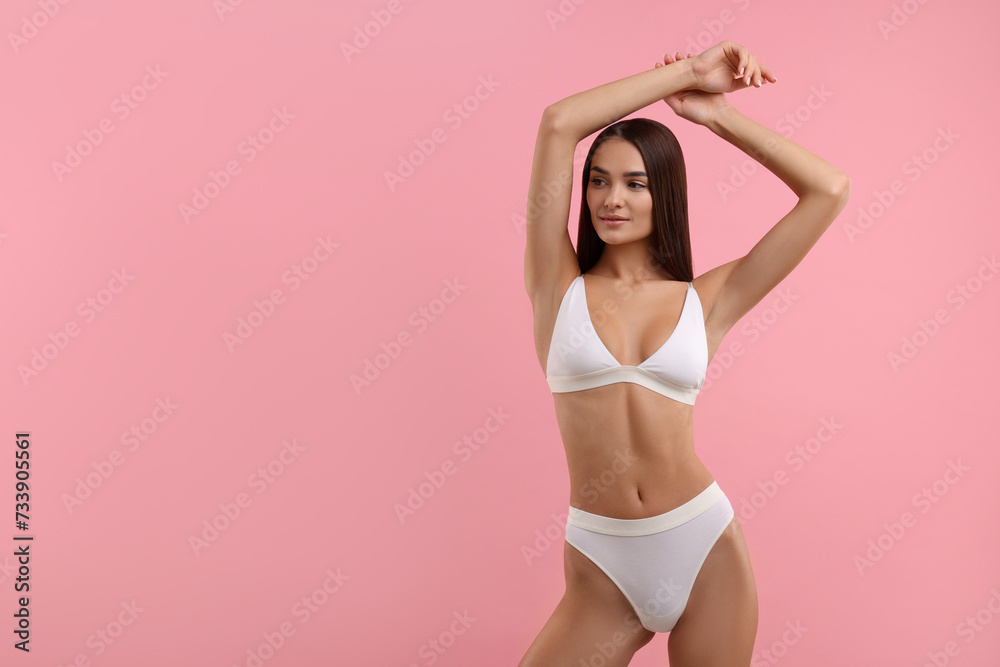 Wall mural Young woman in stylish white bikini on pink background. Space for text