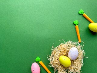 Happy Easter postcard. Colored Easter eggs in nest on green background, image with selective focus, top view