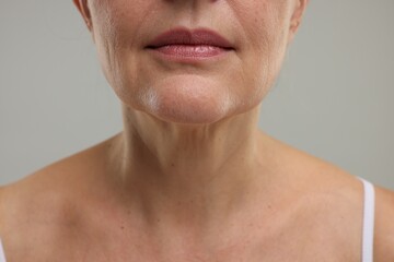 Fototapeta premium Mature woman with healthy skin on grey background, closeup