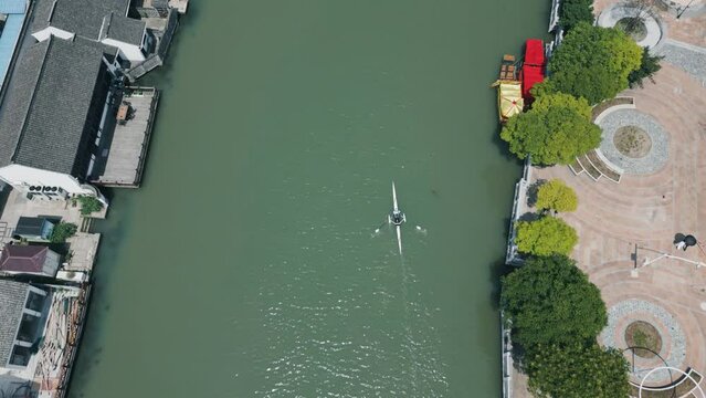 Aerial view, kayak cruising through a river in ancient town.