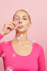 Young blond woman blowing bubbles 