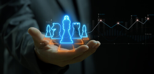 Businessman holding neon chess board game on his hand. Strategy, growth business, economy, finance...