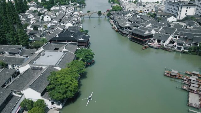 Aerial view, kayak cruising through a river in ancient town.