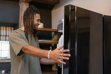 Man standing next to open fridge