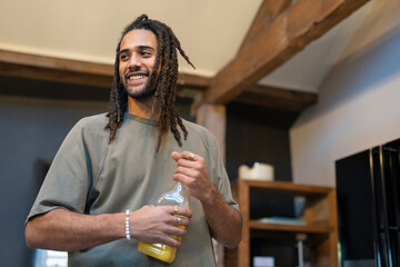 Man with dreads holding bottle of orange juice