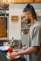 Men with dreads cutting vegetables in kitchen