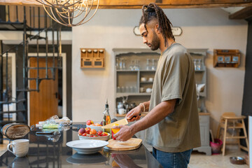 Men with dreads cutting vegetables in kitchen