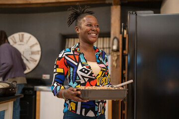 Fototapeta na wymiar Smiling woman carries food in kitchen 