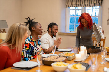 Cheerful friends look at fresh food on table 