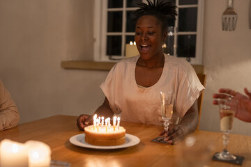 Fototapeta na wymiar Woman about to blow birthday candles on cake