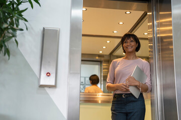 Fototapeta na wymiar Businesswoman walking out of elevator in office