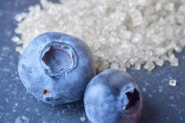 Macro shot of fresh raw blueberry. Clear sharp details and texture. Sugar is on background....