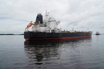 Ecological risks from cargo ships in the sensitive biodiversity of Amazonia. Old black oil tanker ship under the flag of Liberia on the Amazon River near the city of Juriti, Para state, Brazil.