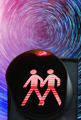 Same sex pedestrian red traffic light on the background of star tracks at night time