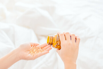 Fish oil capsules closeup in hand for good health. Shark fish oil in a capsule.