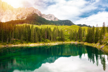 Carezza lake surrounded by forest and mountains in Dolomite alps, Italy