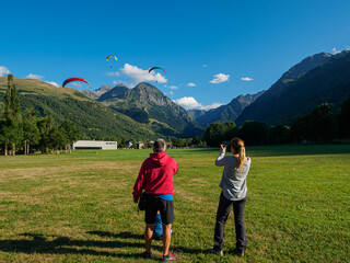 An instructor from a paragliding school giving instructions to his students so that the approach...