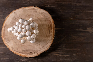 Closeup of a bunch of shimeji mushrooms on wooden background, with selective focus