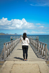 A Girl Standing On A Wooden Pier Looking At A Very Beautiful Sea View