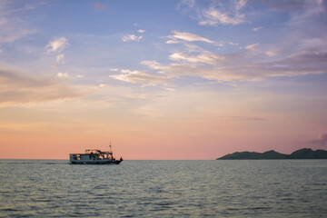 Boat Sailing Across The Sea With Beautiful Sunset In The Background
