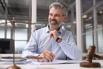 Portrait of smiling lawyer at table in office