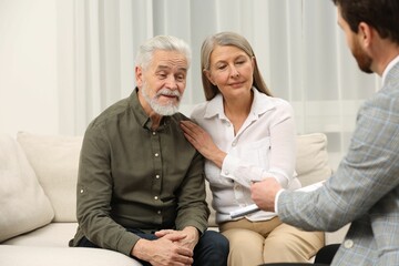 Notary consulting senior couple about Last Will and Testament in office